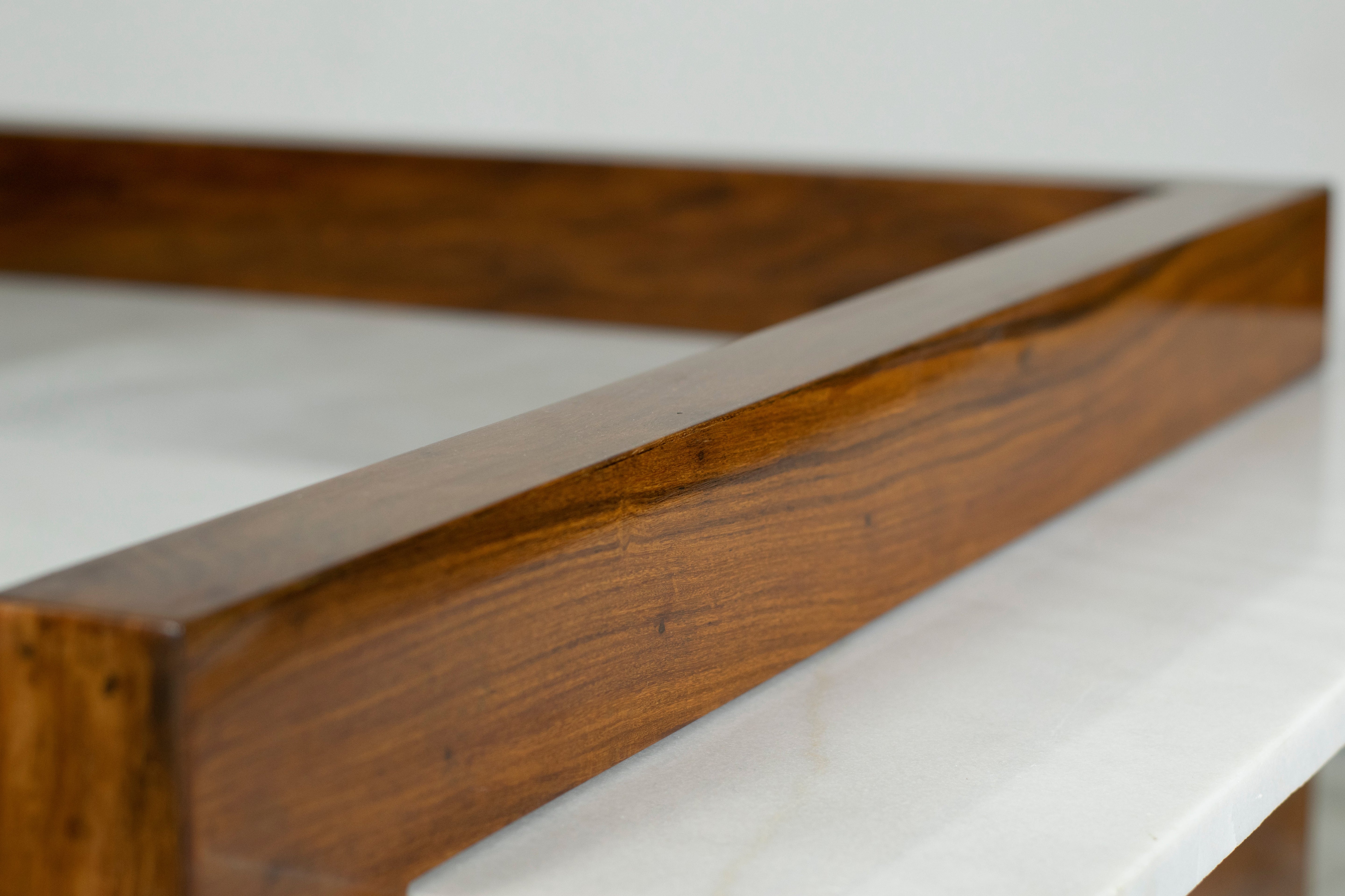 Close-up of white marble slab set into the rosewood tabletop of the coffee table