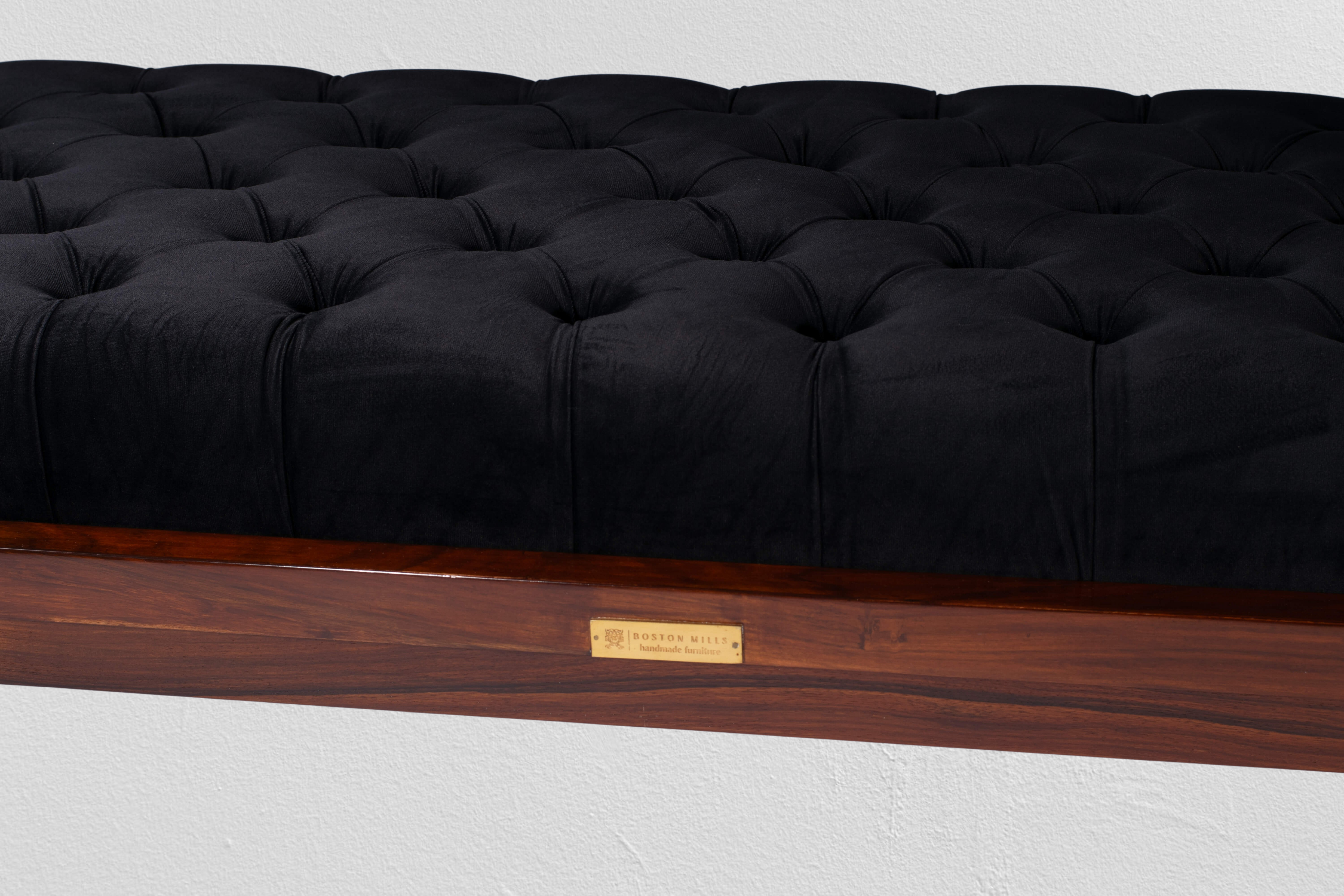 Detail of the black leather cushion’s tufting and hand-stitched seam on rosewood frame