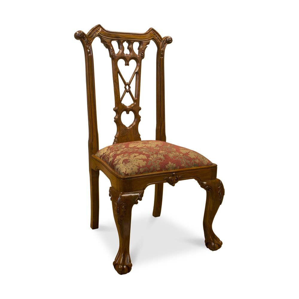 Angled view of hand-carved rosewood chair showcasing sculptural backrest and curved legs on white background